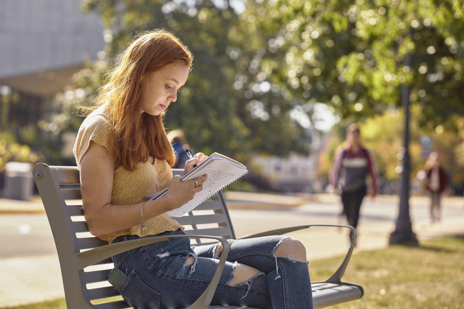 一位<a href='http://9aix.svztur.com'>全球十大赌钱排行app</a>学院的学生在校园里的长椅上读书.